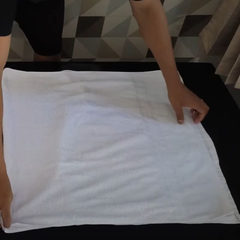 Gấp 2 góc khăn tắm vào giữa Gấp 2 góc khăn tắm vào giữa