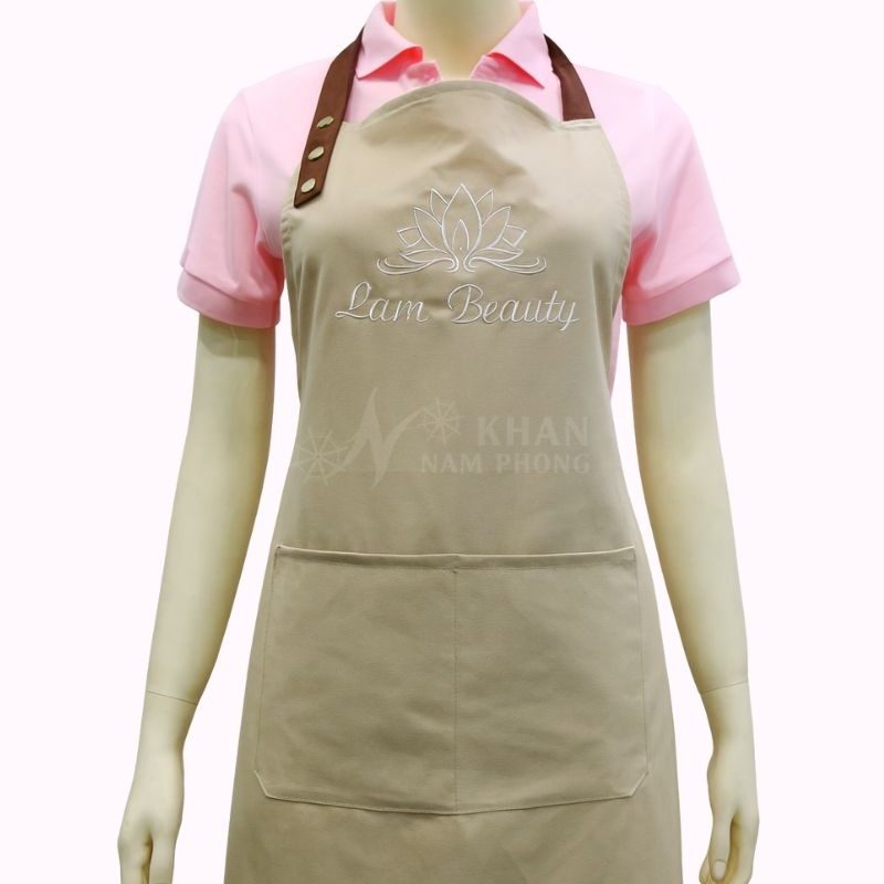 Tạp Dề Spa Màu Nâu Nhạt Cotton Lạnh Cổ Yếm Freesize Thêu Logo Lam Beauty