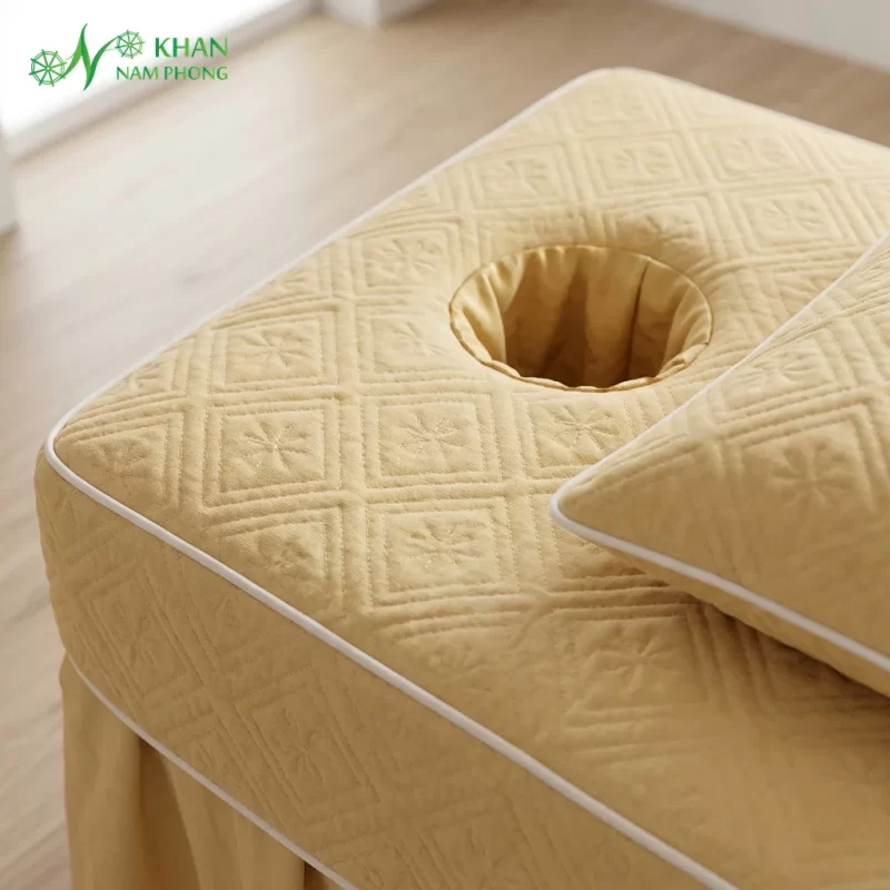 Cận cảnh chất liệu chần bông hình quả trám và lỗ úp mặt ga spa màu vàng nhạt