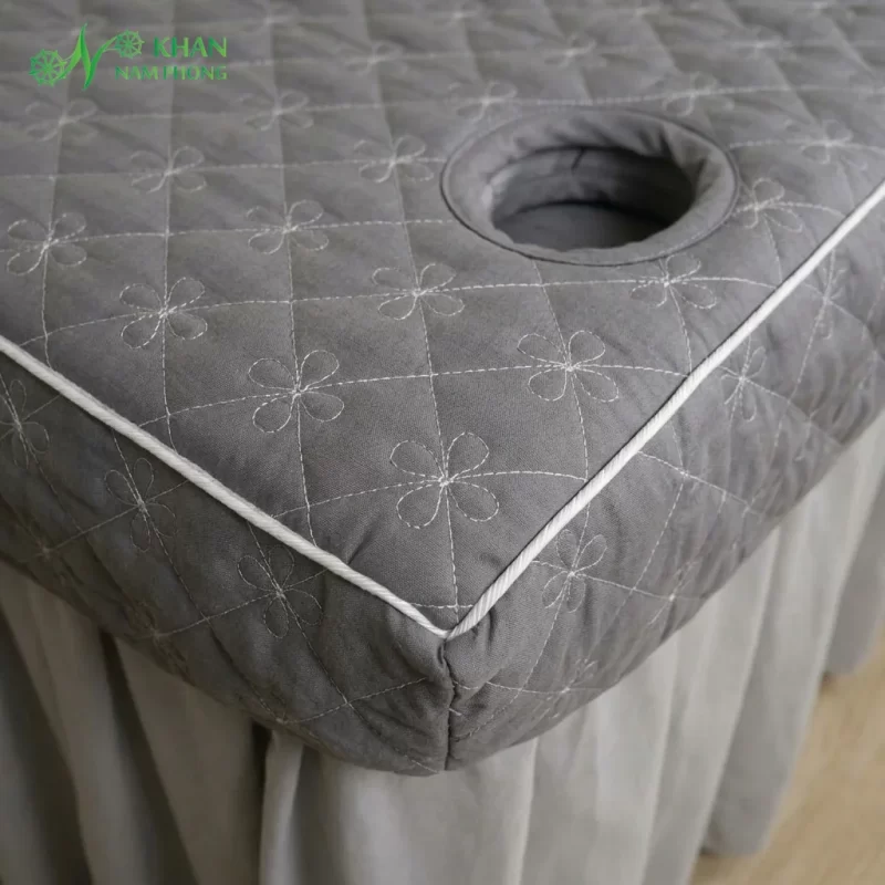 Cận cảnh họa tiết hoa 4 cánh thêu chần bông quả trám và lỗ úp mặt ga giường spa cotton