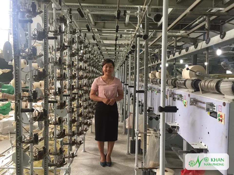 Lê Thị Nhung – Người Sáng Lập, Giám Đốc (Ceo) Khăn Nam Phong Lê Thị Nhung đứng giữa hai dãy máy mắc sợi trong nhà máy dệt Khăn Nam Phong