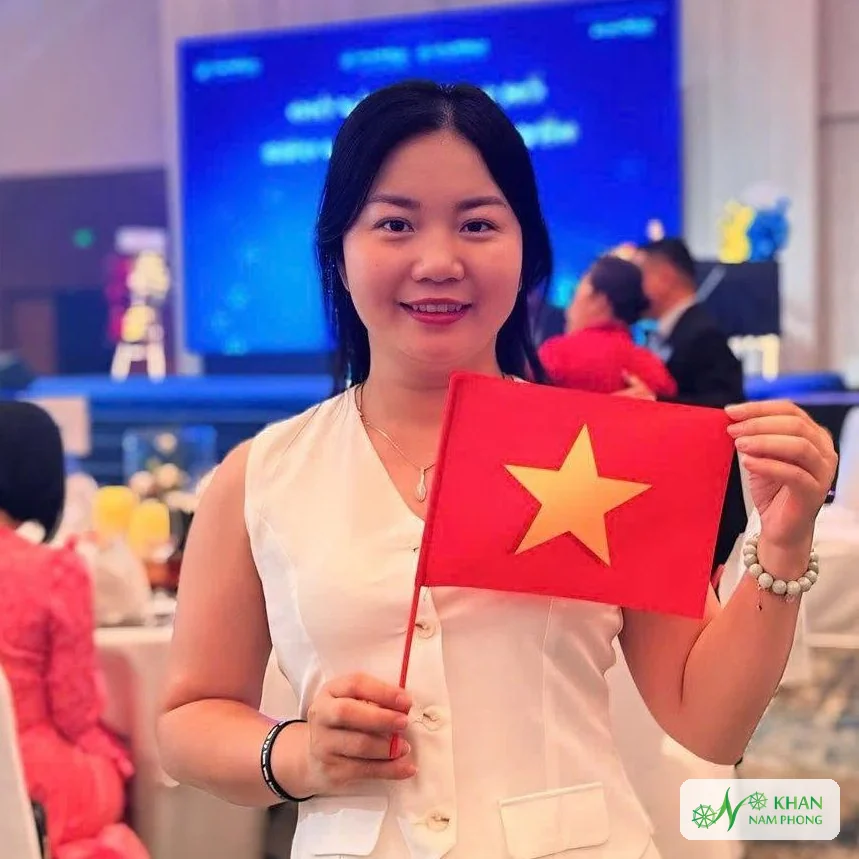 Lê Thị Nhung – Người Sáng Lập, Giám Đốc (Ceo) Khăn Nam Phong Lê Thị Nhung, người sáng lập và giám đốc Khăn Nam Phong, cầm lá cờ Việt Nam tại một sự kiện