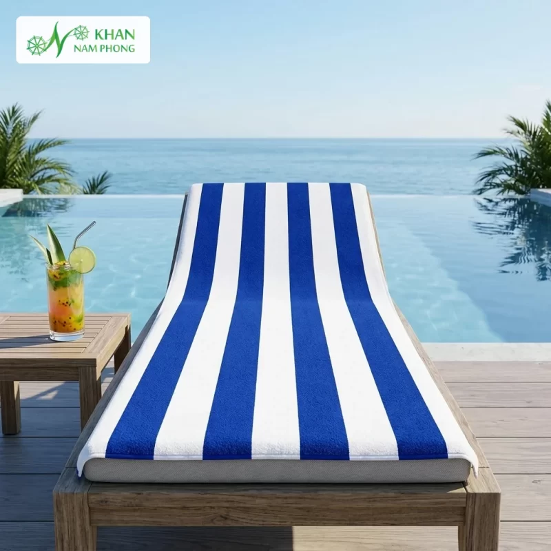 Khăn tắm hồ bơi cotton sọc xanh trắng thương hiệu Khăn Nam Phong trải dài trên ghế tắm nắng bể bơi vô cực