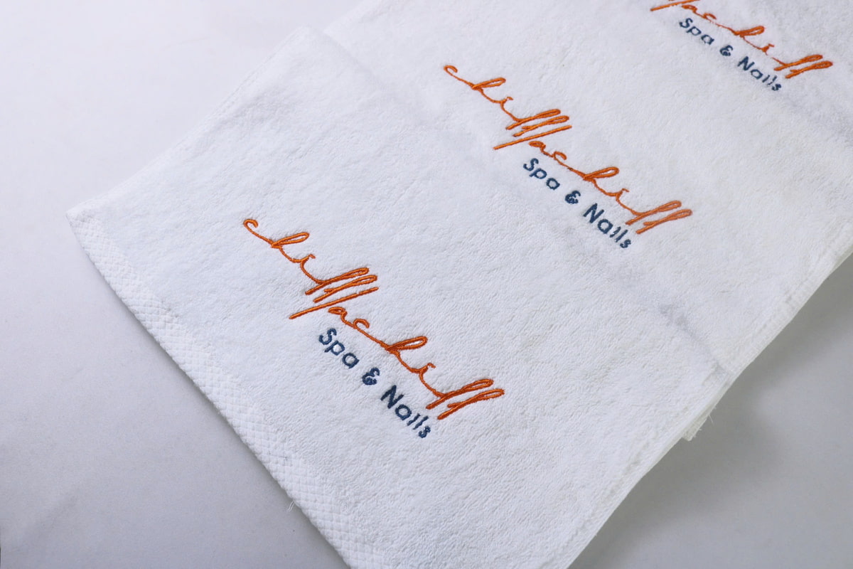 Khăn Trắng Cotton Thêu Logo Cam Nổi Bật Chilllachill Spa &Amp; Nails Khăn trắng cotton thêu logo cam nổi bật Chilllachill Spa & Nails