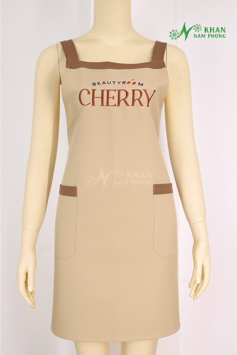 Tạp Dề Nail Màu Kem Sữa Phối Viền Nâu Cotton Lạnh Thêu Logo Beauty Room Cherry Freesize Tạp dề nail màu kem sữa phối viền nâu cotton lạnh thêu logo Beauty Room Cherry freesize