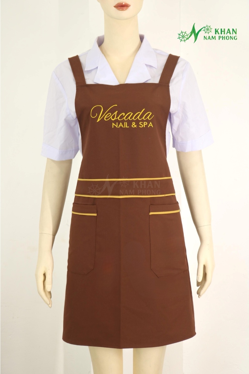 Tạp Dề Nail Màu Nâu Phối Vàng Cotton Lạnh Thêu Logo - Freesize Tạp dề nail màu nâu phối vàng cotton lạnh thêu logo - freesize